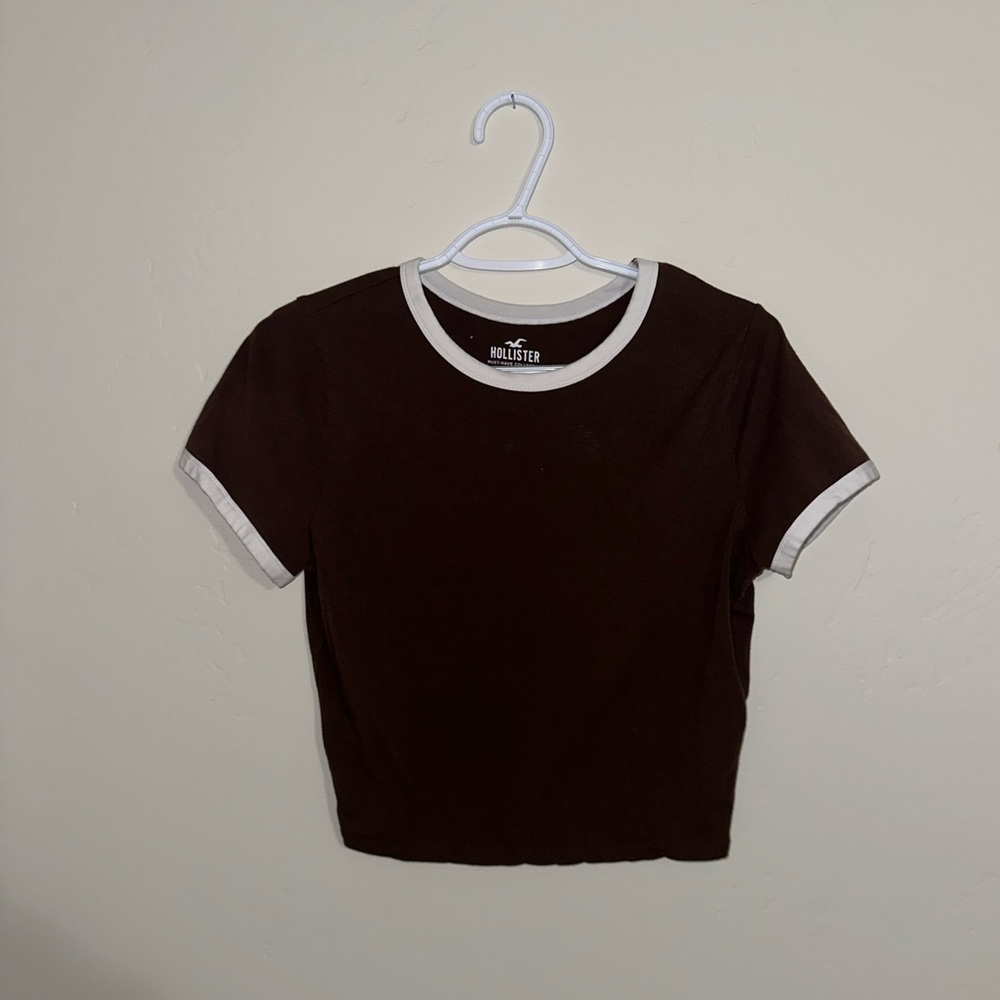 A brown Hollister shirt with white trim. It is from their Must-Have collection.